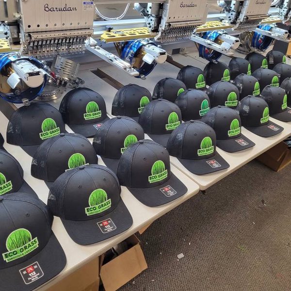 Trucker hats for a landscaping company, off the machines