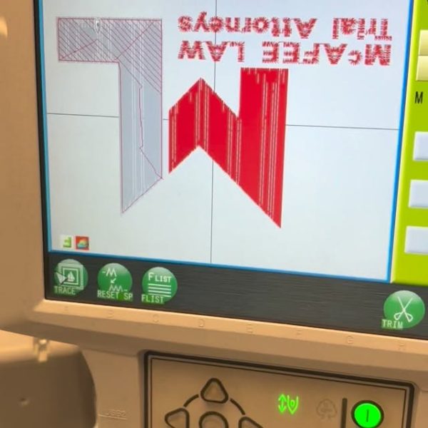Embroidery machine screen showing a law firm logo ready to stitch
